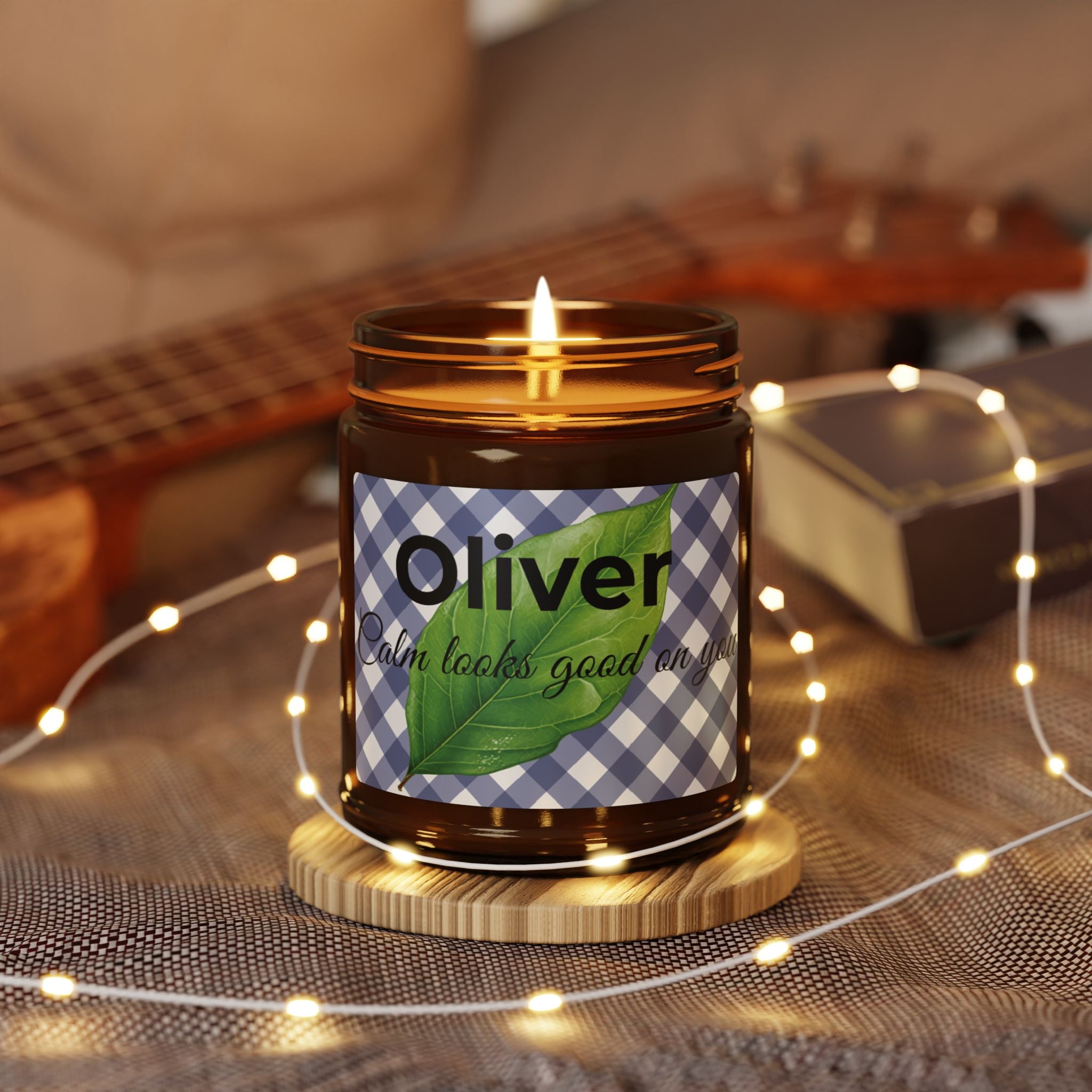 Close-up of blue gingham candle label with bold name and botanical leaf motif