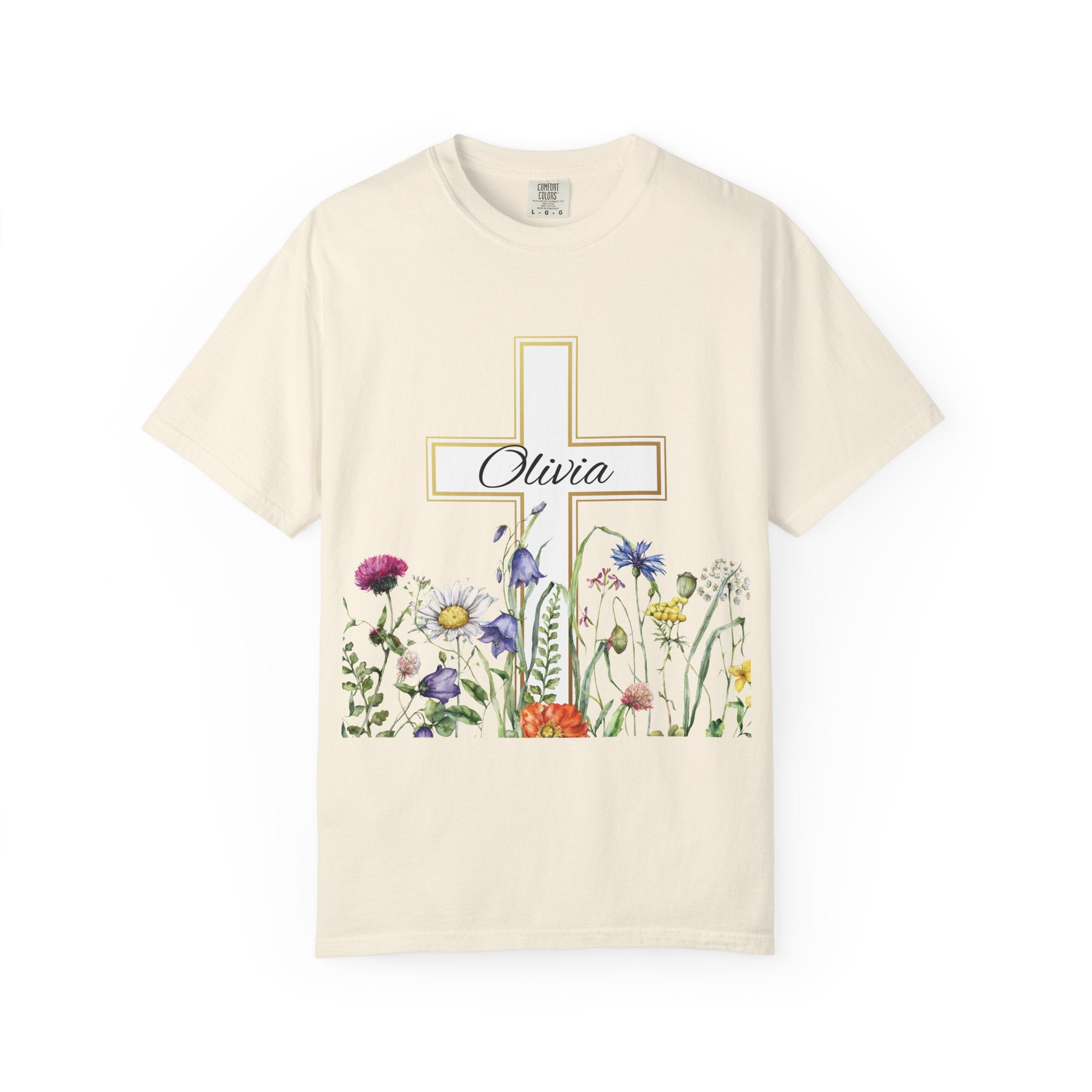 Close-up of golden cross and wildflower artwork on t-shirt